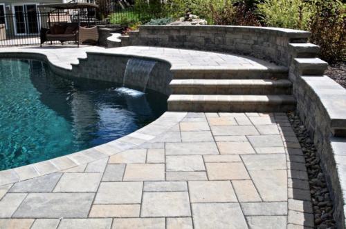 Natural Stone retaining wall around pool with waterfall