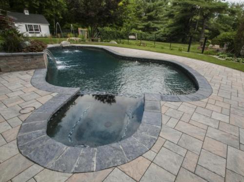 Pool patio with pavers and water fountain. 